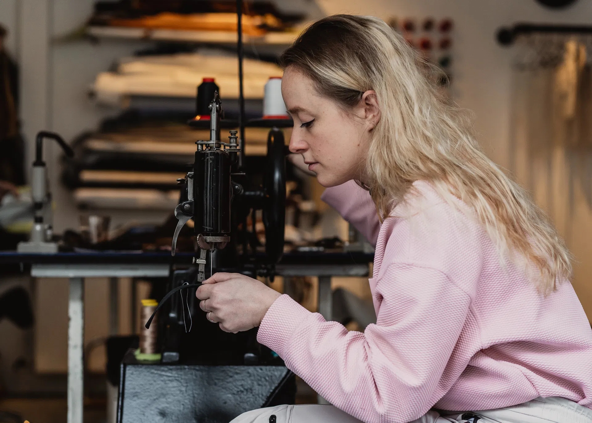 Foto van Saar van SAARBARBAARS in haar atelier aan het werk achter een naaimachine