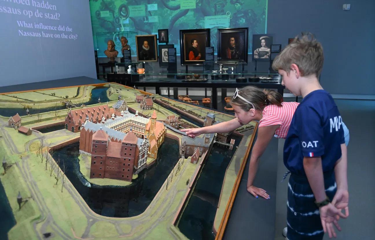 Two children by a historical model of Breda Castle.