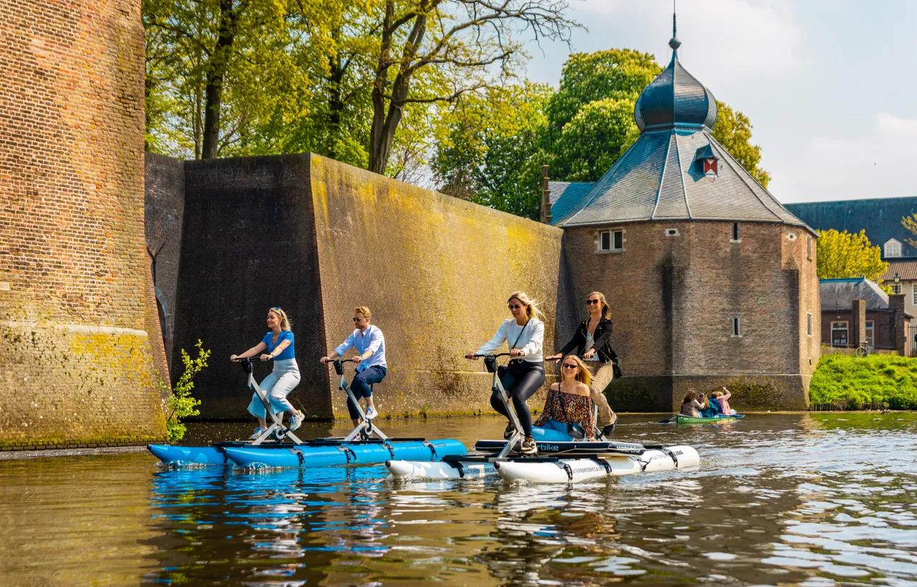 Vier mensen op twee tandem waterbikes bij het Spanjaardsgat Breda.