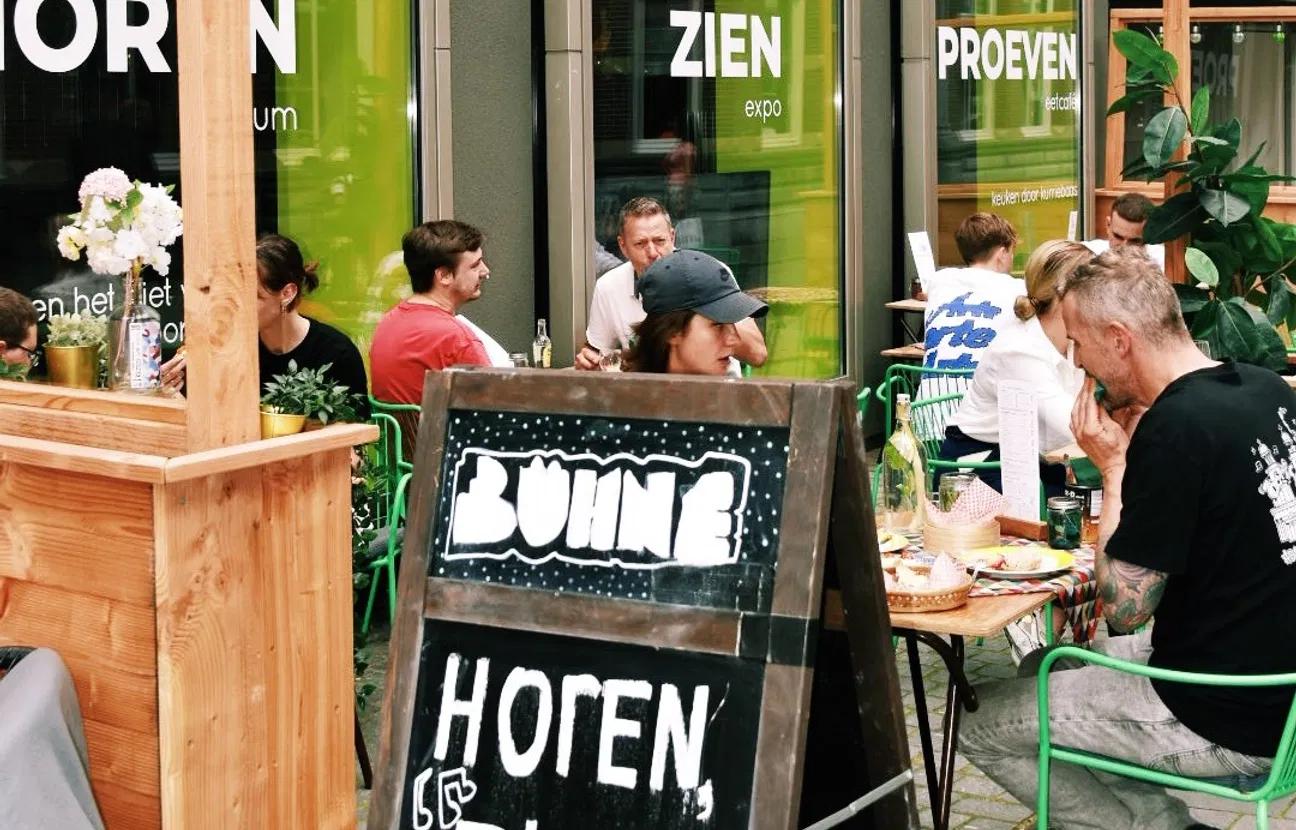 people on terrace stage with street sign in foreground